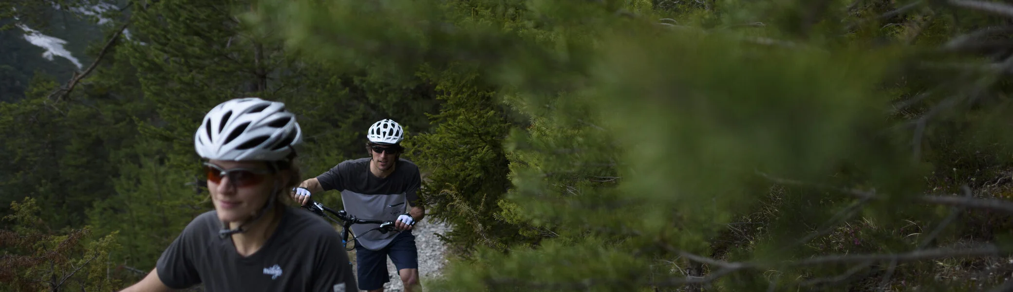 Ein Mountainbiker schiebt sein Rad auf einem Trail in den Bergen. | © DAV/Wolfgang Ehn